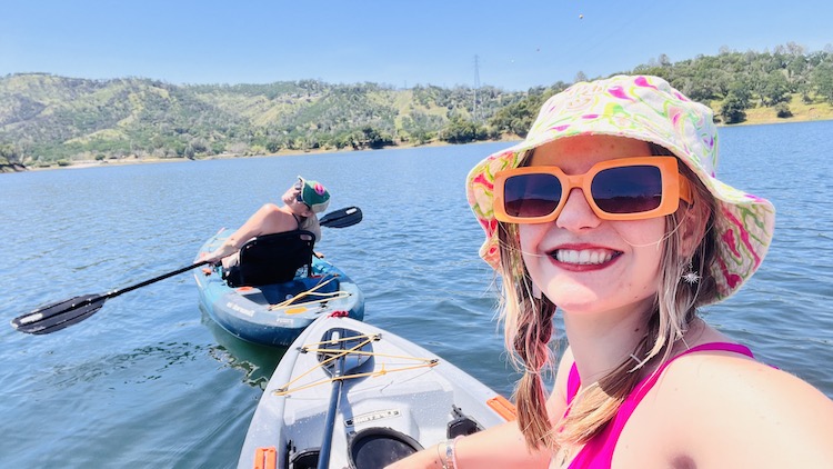 Woman kayaking and taking selfie picture.